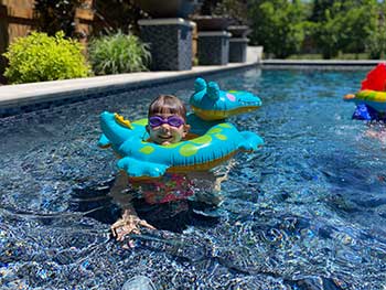 child in swimming pool with inflatable