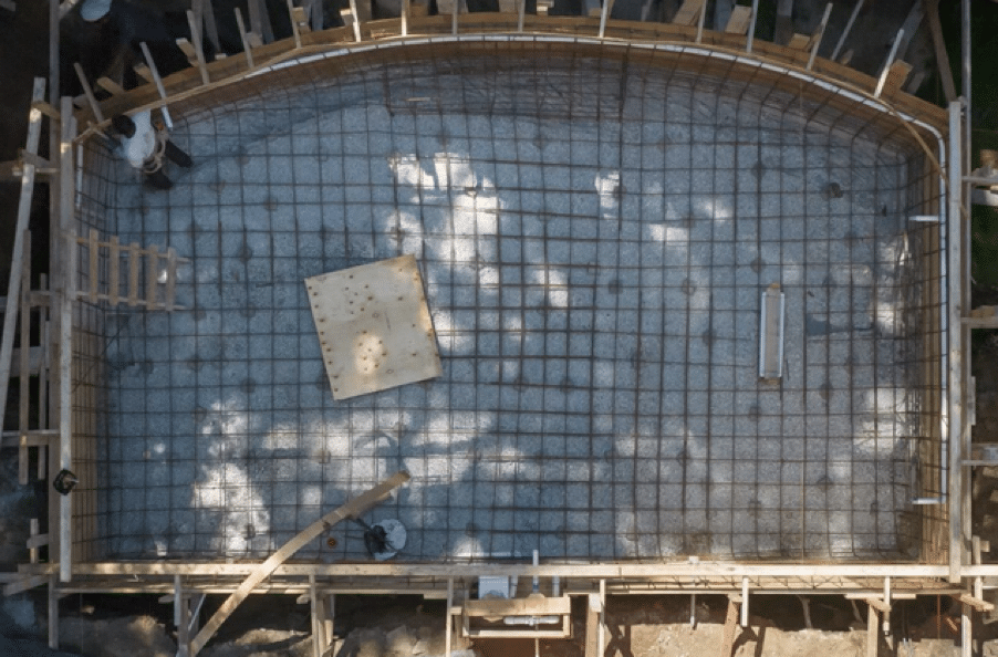 Overhead image of the Gib-San Pools team constructing the form of a custom pool and installing plumping and rebar.