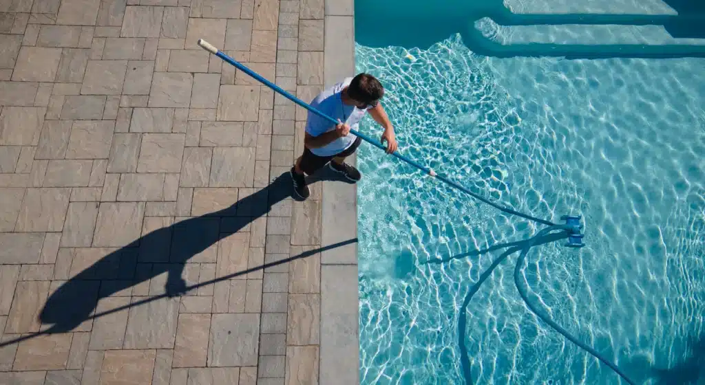 Gib-San Pools team member vacuuming swimming pool during spring pool opening service in Ontario