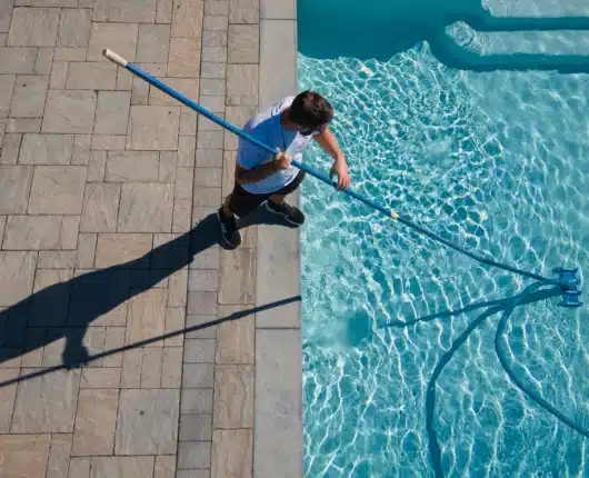 Gib-San Pools team member vacuuming swimming pool during spring pool opening service in Ontario