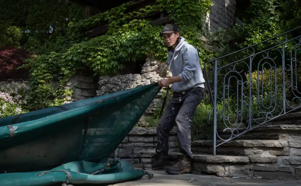 Pool technician removing pool cover during pool opening